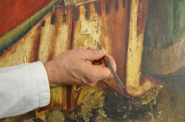 Santa Caterina durante l'intervento di restauro - rifinitura a bisturi delle vecchie stuccature: pulitura del gesso debordante sulla superficie pittorica - ph.: ETRA S.N.C.